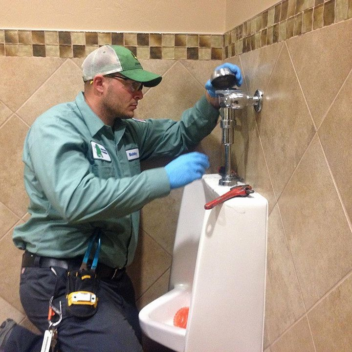 Plumbing technician servicing commercial plumbing equipment